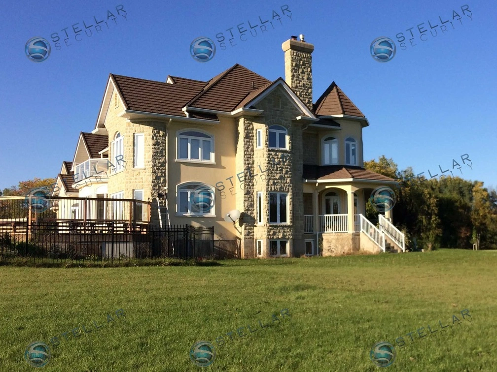 Wide exterior view of custom luxury Cambridge estate with complete residential security camera coverage