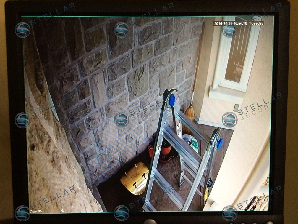 Monitor display showing live 4K security camera feed of basement outdoor stairwell in Cambridge