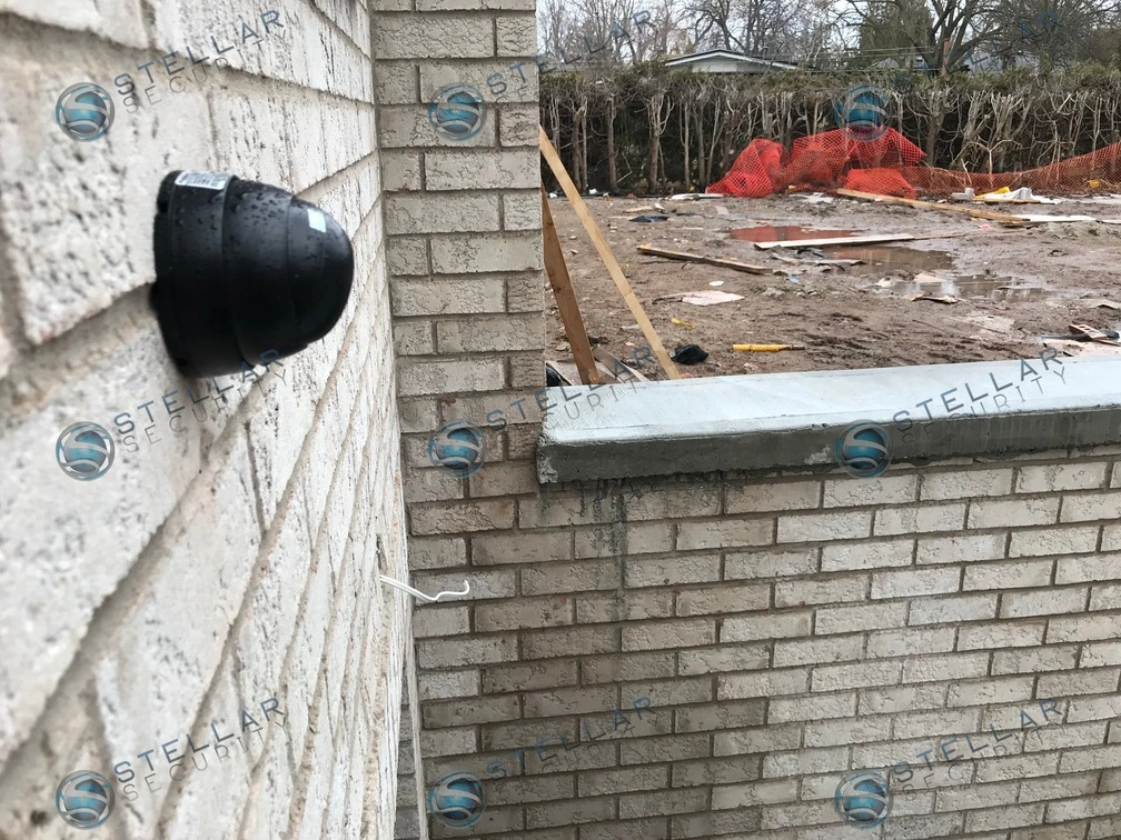 Exterior security camera mounted on light brick wall of a residential home under construction in Mississauga