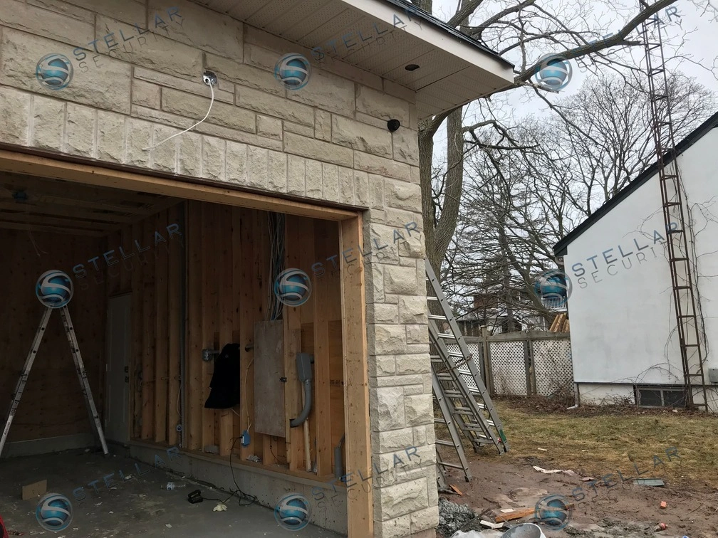 Security camera rough-in wiring and mounting location above garage frame during Mississauga home construction