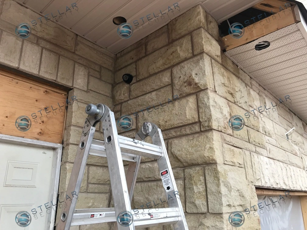 Outdoor security camera mounted on stone facade exterior corner near garage in Mississauga