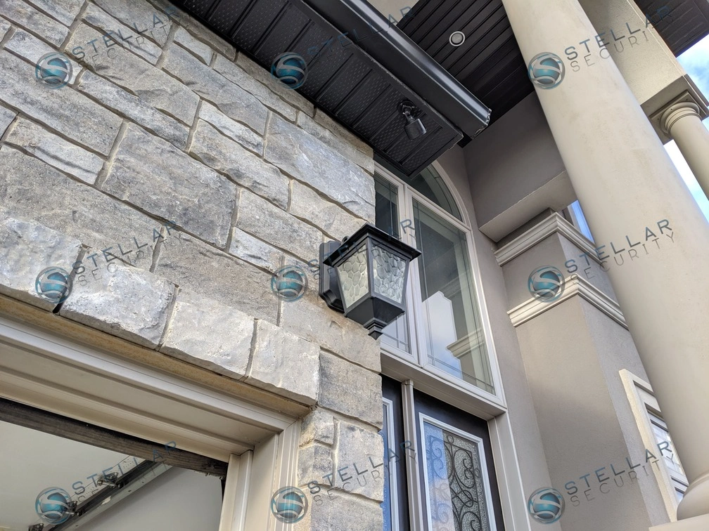 Security camera mounted high above stone pillar at front entrance of Toronto home