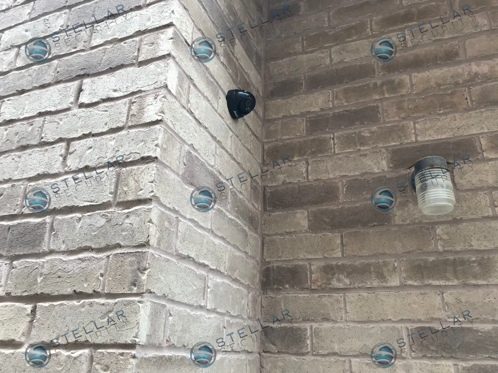 Close-up of black turret security camera installed on exterior brick corner of a Vaughan residence