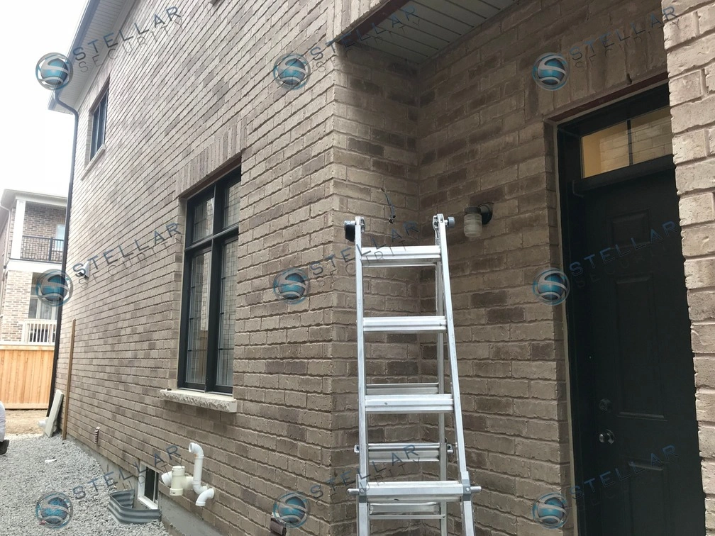 Security camera installation targeting side door entrance on brick exterior of a Vaughan home