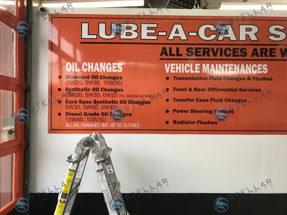 Interior view near customer service sign and A-frame ladder during office area camera installation