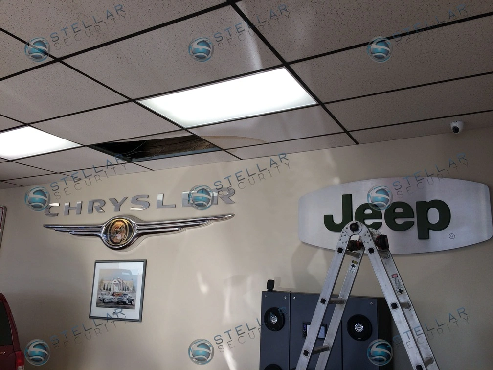 Clean drop ceiling PoE security camera wiring installation inside auto dealership interior