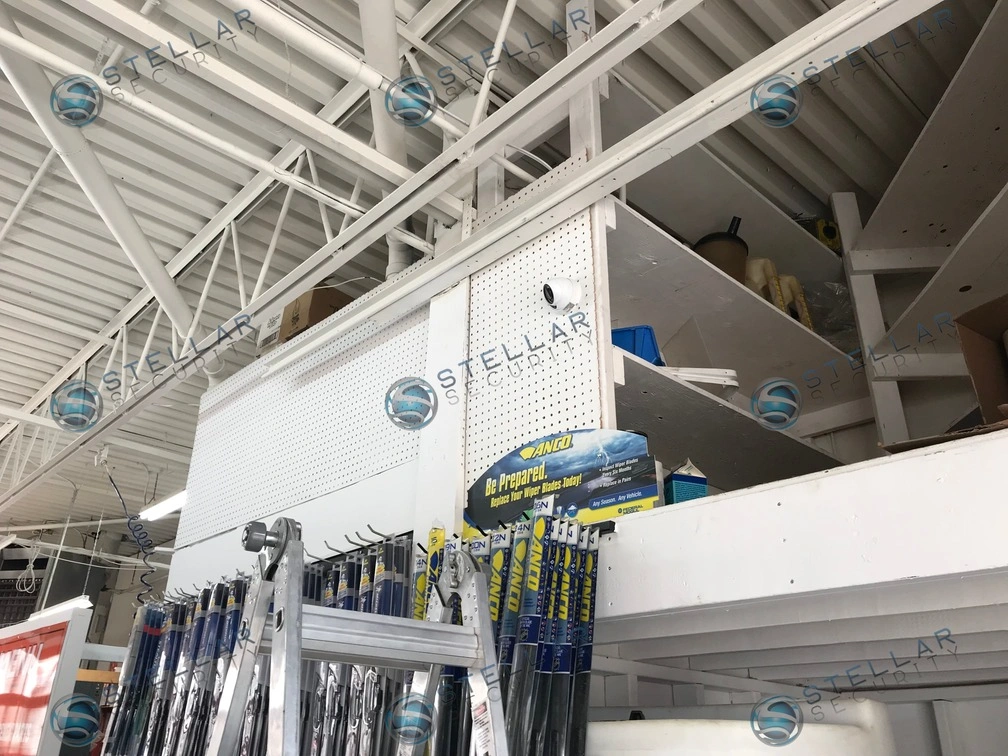Security camera installed on white open web steel joist ceiling inside high-bay mechanic garage