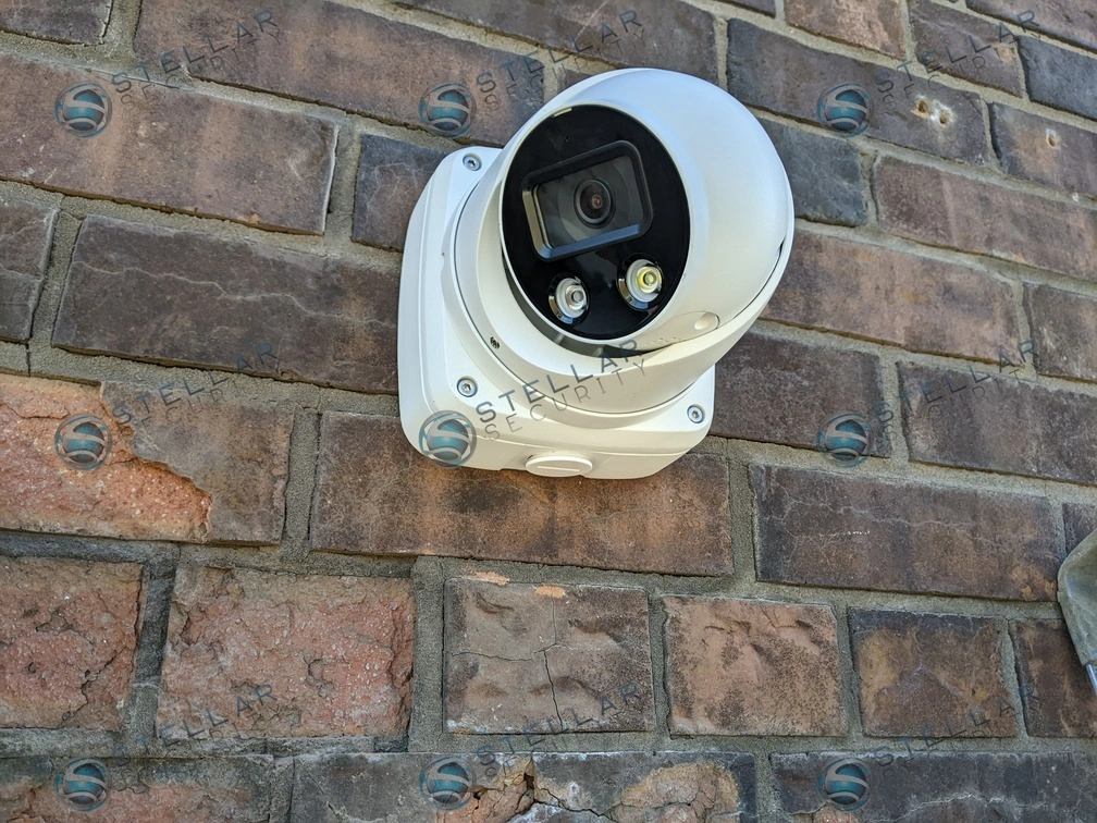 Weatherproof commercial security camera mounted securely to a exterior brick wall.