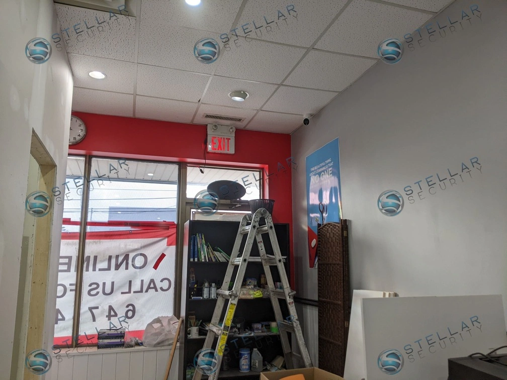Front entrance window of a commercial learning center with installation ladder set up for camera mounting.