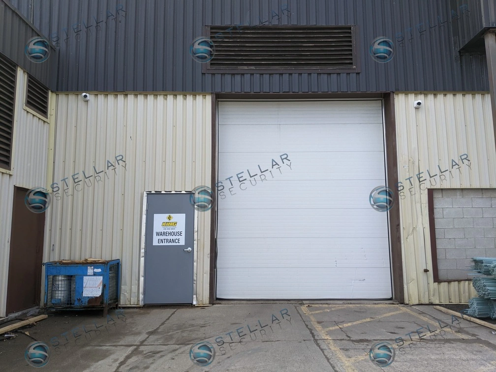 Full exterior building view of a commercial industrial warehouse equipped with outdoor security cameras.