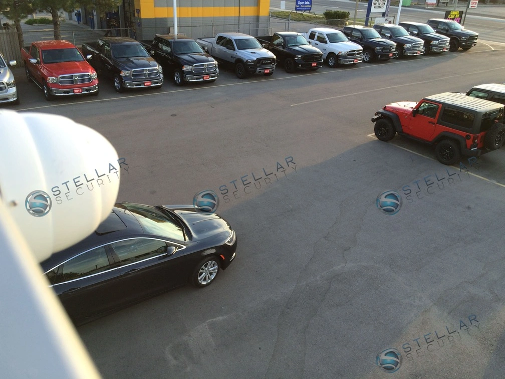 Elevated security camera view of dealership outdoor inventory parking lot
