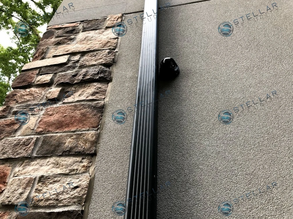 Dark turret security camera mounted on stucco exterior corner adjacent to stone facade in Etobicoke