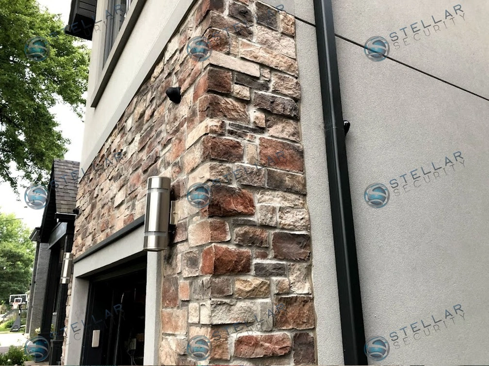 Angle shot of security camera installed on stone corner wall above double garage entrance in Etobicoke