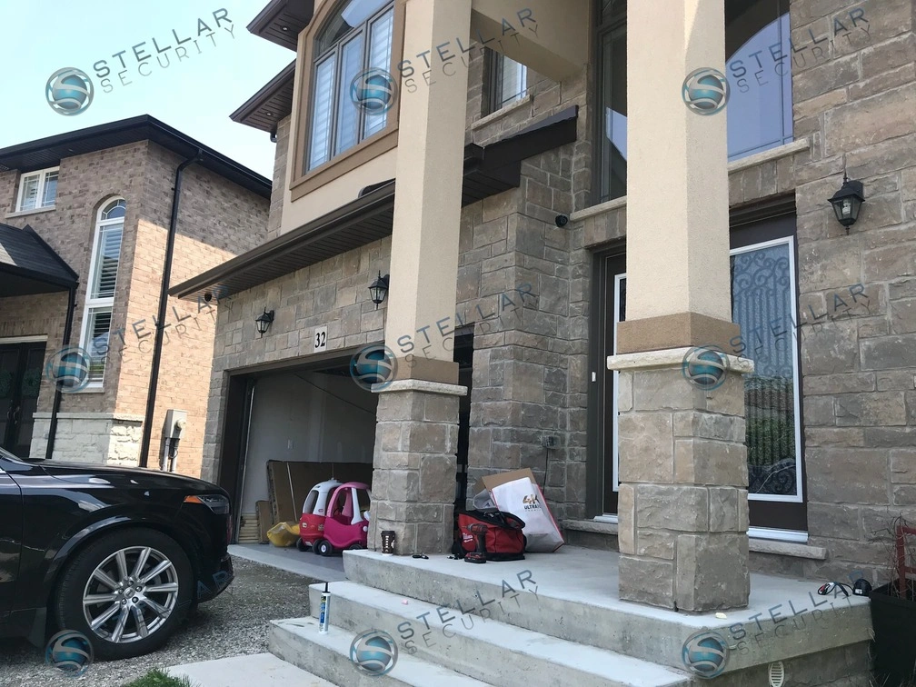 Angle view showing front porch steps, stone pillars, and security camera placement in Hamilton