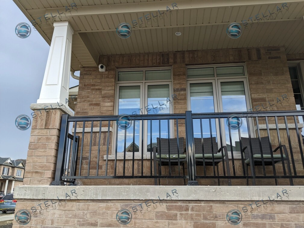 Security camera positioned above covered front porch seating area and glass door entry in Kitchener