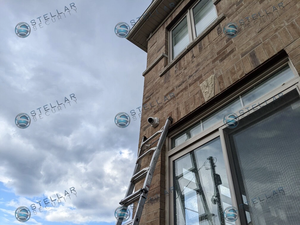 Security camera mounted near upper window frame monitoring side property line in Kitchener