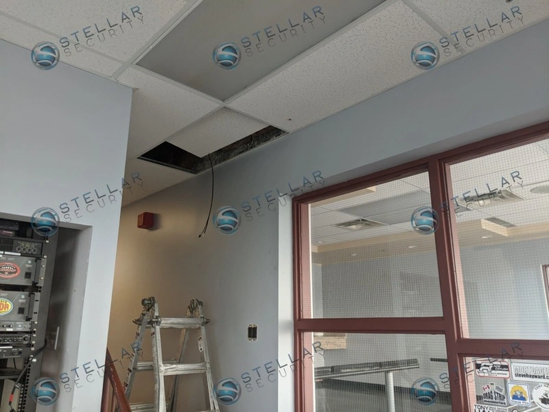 Server rack setup and drop ceiling cabling installation in race track control tower office.