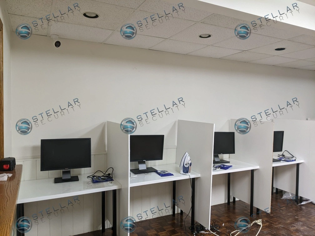 Commercial indoor security camera positioned above student computer workstations in a learning lab.