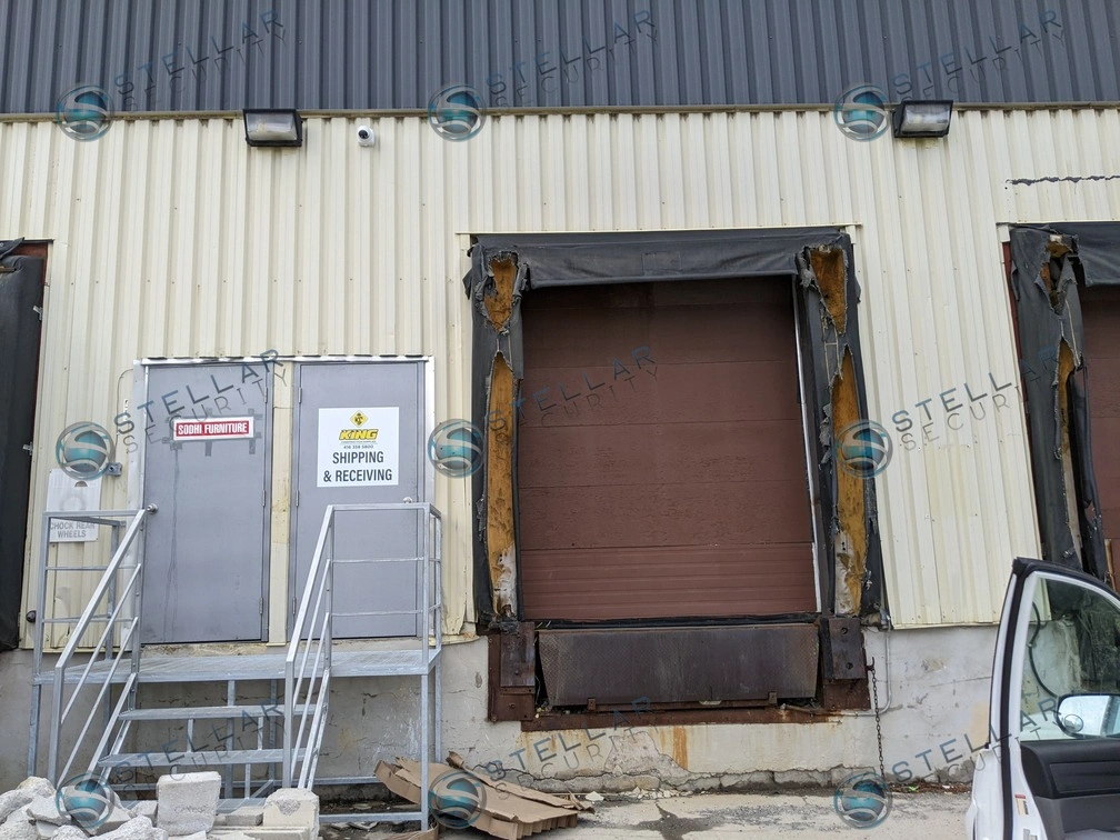 Commercial loading bay doors and shipping entrance monitored by high-definition security cameras.